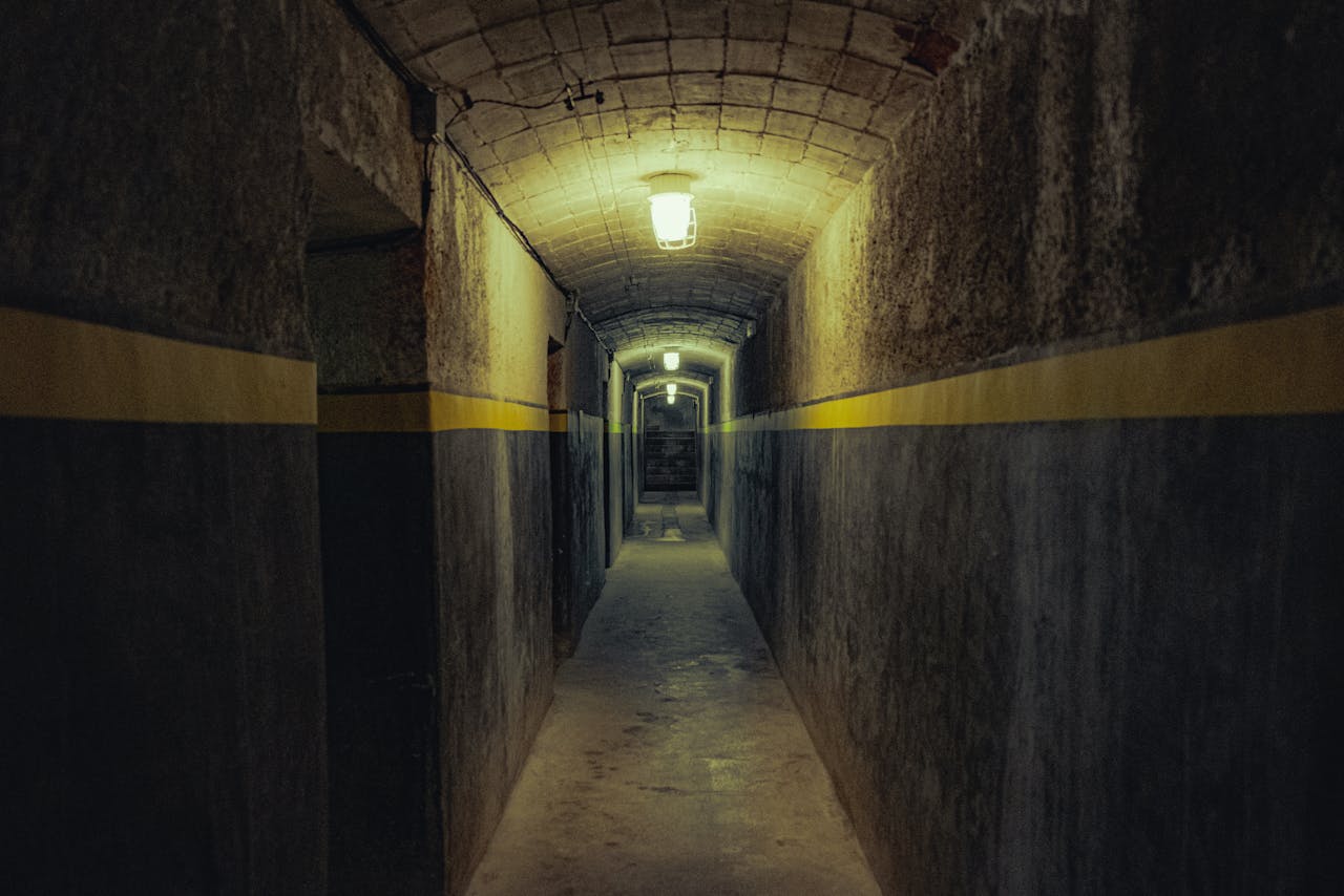 A dimly lit underground tunnel in Girona with symmetrical lines and moody ambiance.